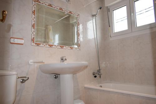 a bathroom with a sink and a toilet and a mirror at Hotel VIDA Ostra Marina in Sanxenxo