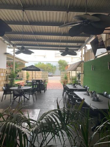 an outdoor patio with tables and chairs and umbrellas at Riverside Hotel in Northam