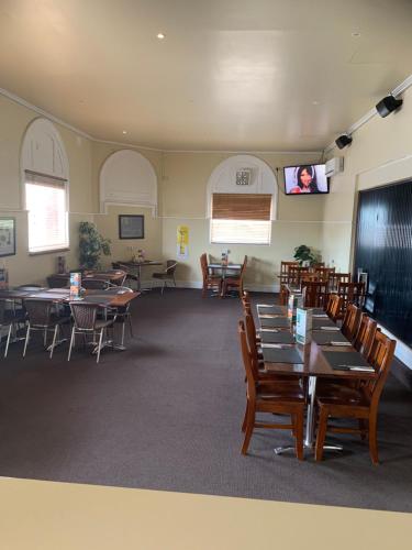a dining room with tables and chairs and a flat screen tv at Riverside Hotel in Northam