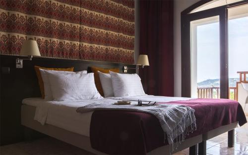 a bedroom with a large bed with white pillows at Almyrida Village & Waterpark in Almirida