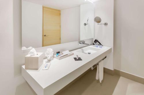 a white bathroom with a sink and a mirror at Wyndham Bogota in Bogotá