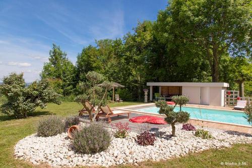 einen Garten mit Pool und ein Haus in der Unterkunft A l'orée du bois - Chambres d'hôtes in Hostun