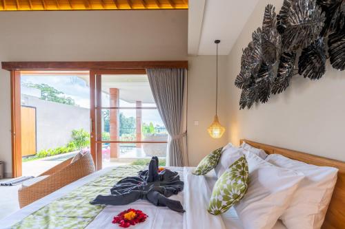 ein Schlafzimmer mit einem Bett mit Blumen darauf in der Unterkunft Arta Private Villa in Ubud