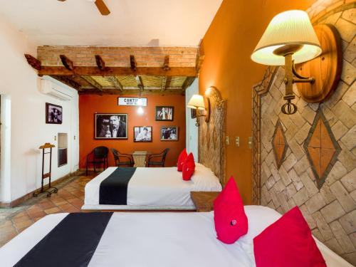 een hotelkamer met 2 bedden en rode kussens bij Hotel Olimpia in Monclova