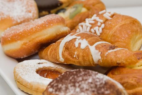 een stapel verschillende soorten donuts op een bord bij Hotel Concorde in Bellaria-Igea Marina