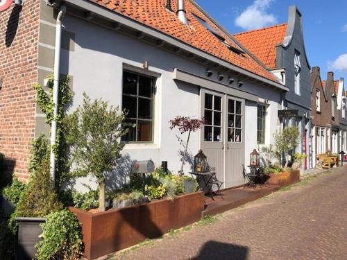 a white and blue house on the side of a street at Logerij De Schuur in Zierikzee