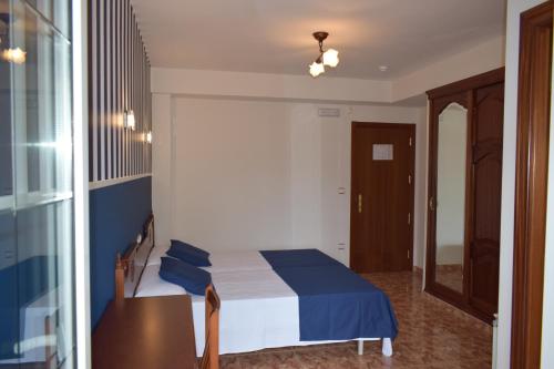 a bedroom with a bed and a table and a mirror at Hotel VIDA Ostra Marina in Sanxenxo
