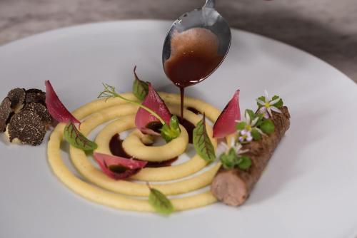 a white plate with a dessert with a spoon at Aressana Spa Hotel & Suites - Small Luxury Hotels of the World in Fira