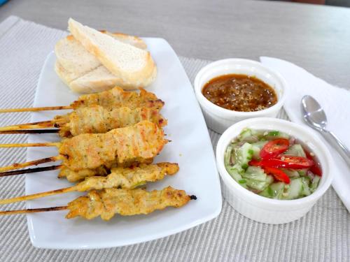 a plate of food with meat and vegetables and dipping sauce at MonPanaNont Wellness Resort & Spa in Mae Taeng