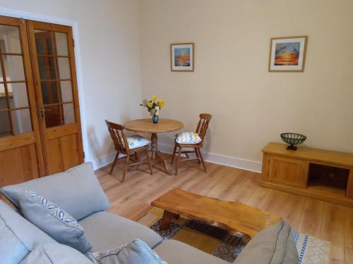 a living room with a couch and a table at Ground Floor Barmouth Centre Apartment With Garden in Barmouth