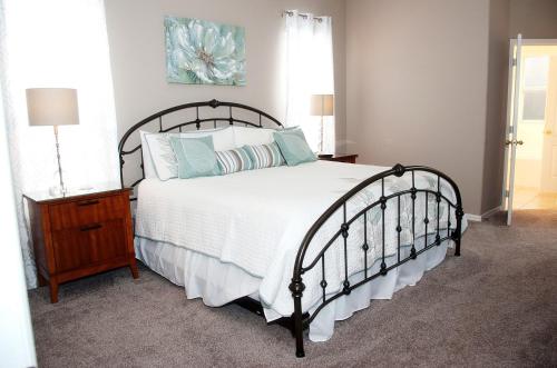 een slaapkamer met een bed met witte lakens en blauwe kussens bij Four-Bedroom Pool Home Kissimmee in Orlando