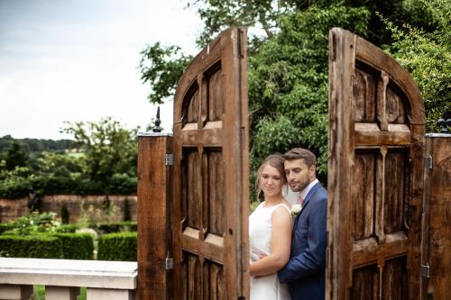 a bride and groom standing in a wooden gate at Nuthurst Grange Country House Hotel & Restaurant in Solihull