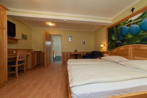 a bedroom with two beds and a kitchen and a desk at Bauernhof Liendl in Keutschach am See