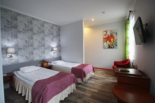 a hotel room with two beds and a chair at NB Hotel with Free Parking in Rīga