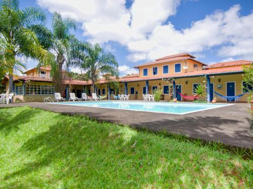 a villa with a swimming pool in front of a house at Pousada Estrada Das Águas, São João del Rei in São João del Rei