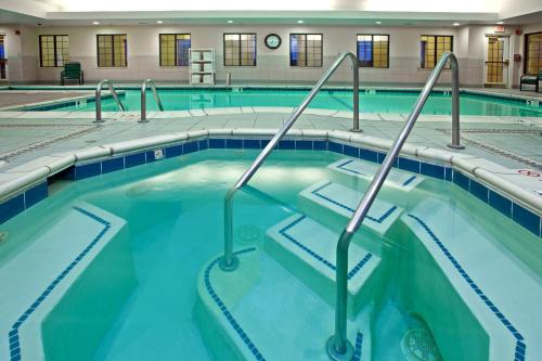 a swimming pool with blue water in a building at Staybridge Suites Indianapolis-Fishers by IHG in Fishers