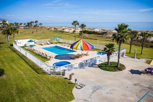 a beach area with umbrellas and lawn chairs at Days Inn & Suites by Wyndham Jekyll Island in Jekyll Island