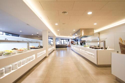 une cuisine avec un long couloir et des comptoirs de restauration dans l'établissement Hotel Gran Garbi & AquaSplash, à Lloret de Mar