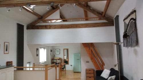 a living room with wooden beams and a room with a couch at Moss Tarn in Ulverston