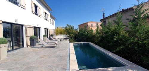 a swimming pool on a patio next to a building at Villa les Pierres d'Antan in Lorgues
