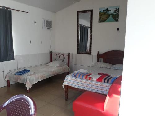 een slaapkamer met 2 bedden en een spiegel bij Pousada dos Corações in Salvaterra