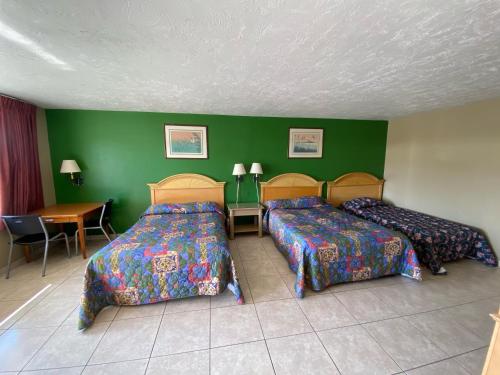 una habitación de hotel con dos camas y una mesa en Economy Inn, en Arcadia