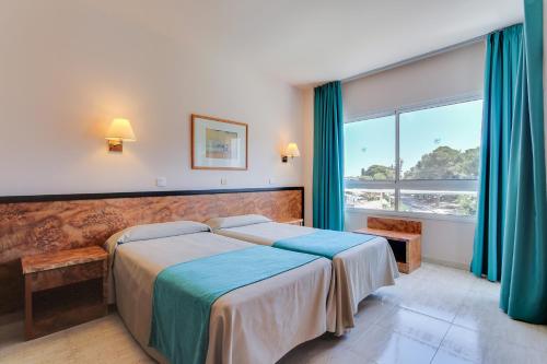 a bedroom with a bed and a large window at Hotel Gran Garbi Mar & AquaSplash in Lloret de Mar