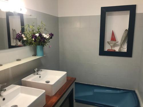 a bathroom with a sink and a vase with flowers at villa fleur de sel in Cuges-les-Pins