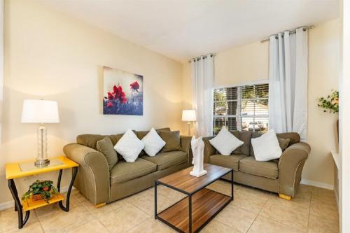 sala de estar con sofá y mesa en Holiday Villas of Kissimmee, en Kissimmee