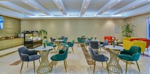 a waiting room with tables and chairs at VISTA HOTEL APARTMENTS DELUXE in Dubai