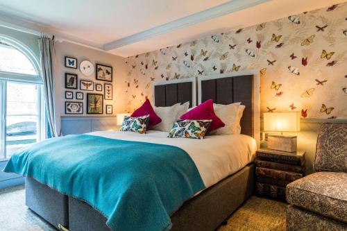a bedroom with a large bed with a blue blanket at Hand and Spear in Weybridge