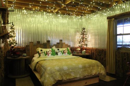 ein Schlafzimmer mit einem Bett mit Weihnachtsbeleuchtung daran in der Unterkunft The Christmas Cabin in Ozark