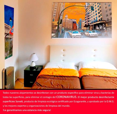 - une chambre avec un lit et une photo d'une ville dans l'établissement Reina Victoria Apartaments & SuiteS TPH, à Madrid