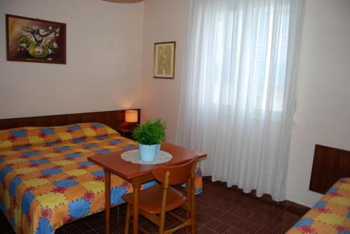 a bedroom with a bed and a table with a plant on it at Casa Monti in Grado