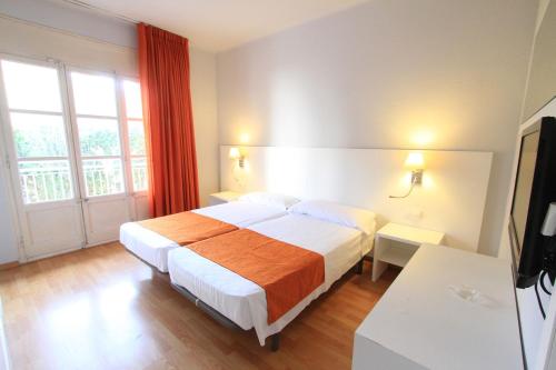 een hotelkamer met een bed en een raam bij Hotel Villa Garbí in Lloret de Mar
