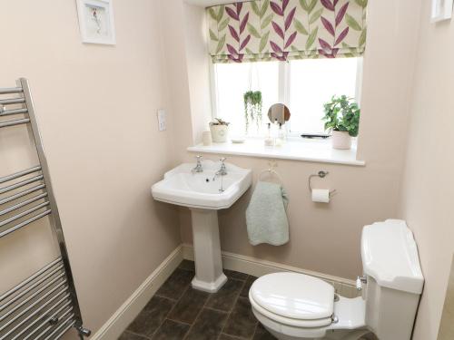 バーナード・キャッスルにあるChurch Cottageのバスルーム(洗面台、トイレ付)、窓が備わります。