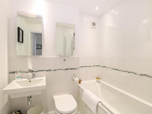 a white bathroom with a sink and a toilet at Tenison House in North Walsham
