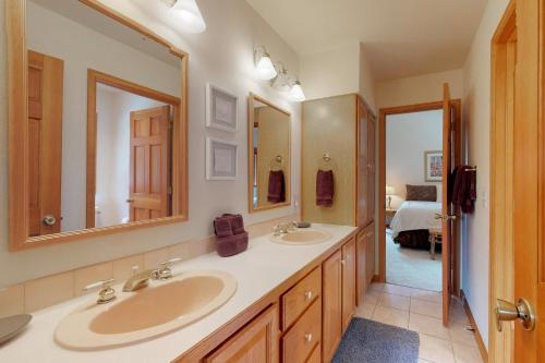 a bathroom with two sinks and two mirrors at Mountain Splendor in Estes Park