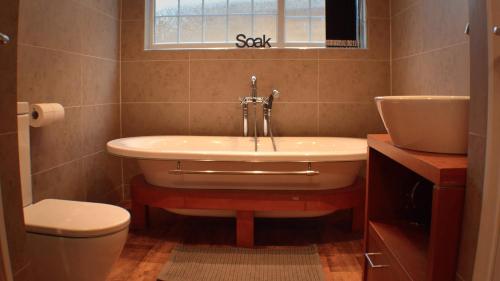 a bathroom with a tub and a toilet and a sink at The Den Studio Apartment - Withernsea in Withernsea