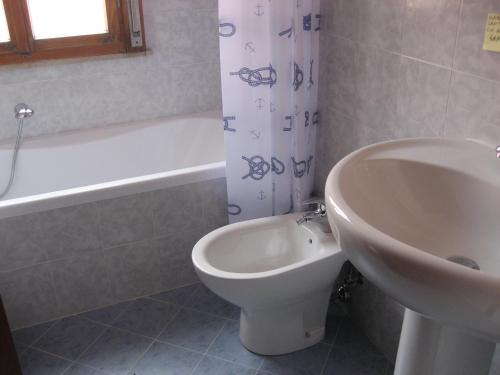 a bathroom with a sink and a toilet and a tub at Villa Al Mare in Grado