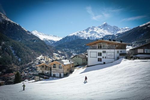 two people are skiing down a snow covered mountain at Chalets - The Peak in Sölden