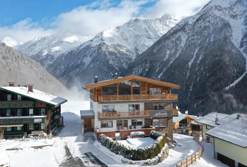 a ski lodge with snow covered mountains in the background at Chalets - The Peak in Sölden
