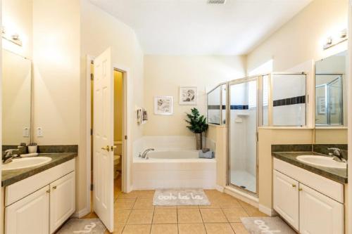 a bathroom with two sinks and a bath tub at Five-Bedroom Pool Home Kissimmee in Orlando