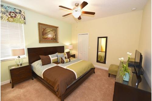 sypialnia z łóżkiem i wentylatorem sufitowym w obiekcie Five-Bedroom Pool Home Kissimmee w Orlando
