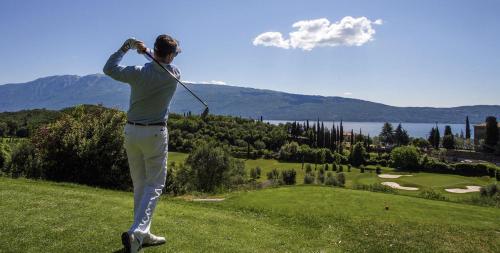 a man swinging a golf club on a golf course at Ennesima Osteria con Alloggio - Bike Hotel in Toscolano Maderno