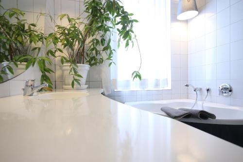 een badkamer met een wit bad en potplanten bij Moderne Studio Apartments und 4 Zimmer Wohnungen in Oberhausen, ideal für Geschäftsreisende und Monteure in Oberhausen