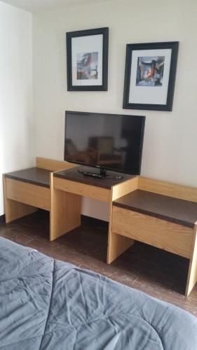 a living room with a television and a bed at Rimbey Motor Inn in Rimbey