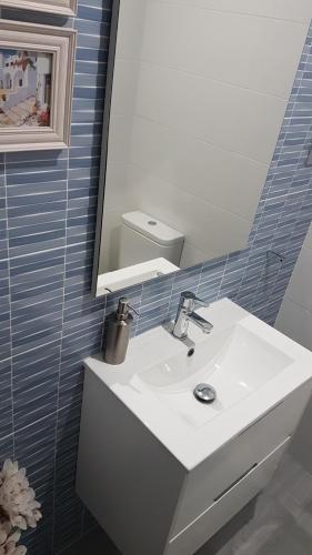 a bathroom with a white sink and a mirror at Vivienda Turístico Erreka Beach in Mundaka