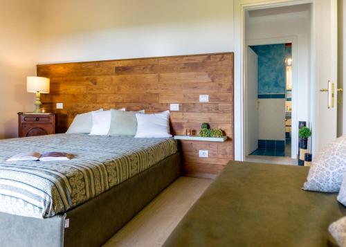 a bedroom with a large bed with a wooden headboard at Residenza Le Galere in Castiglione della Pescaia