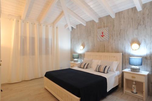 布多尼的住宿－Residence SardegnaSummer Li Mori，一间卧室配有一张带2个床头柜和2盏灯的床。